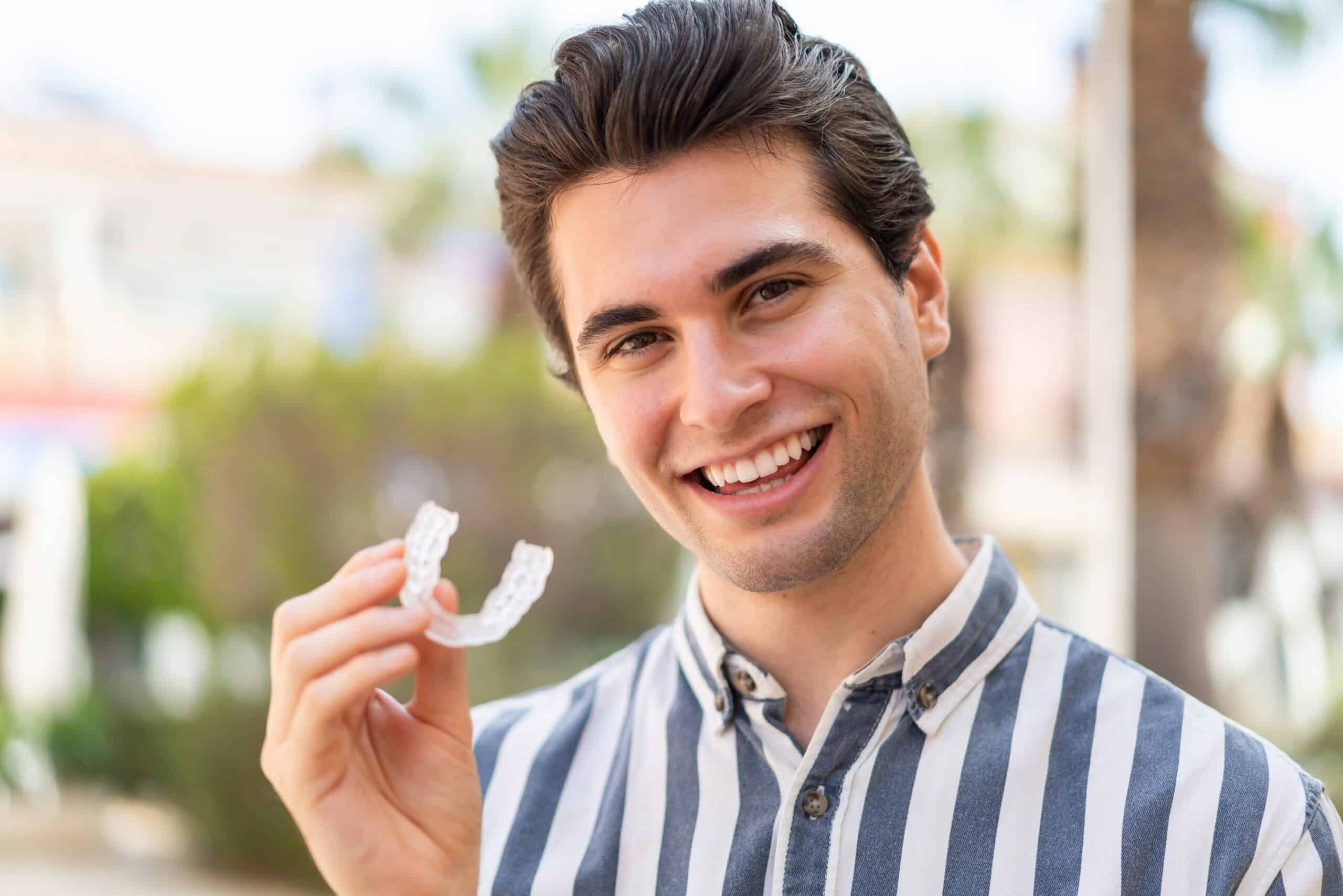 Young,Handsome,Man,Holding,Invisible,Braces,With,Happy,Expression